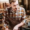 carpenter-holding-chisel-while-carving-wood-in-workshop