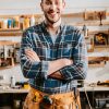 happy-carpenter-in-apron-standing-with-crossed-arms